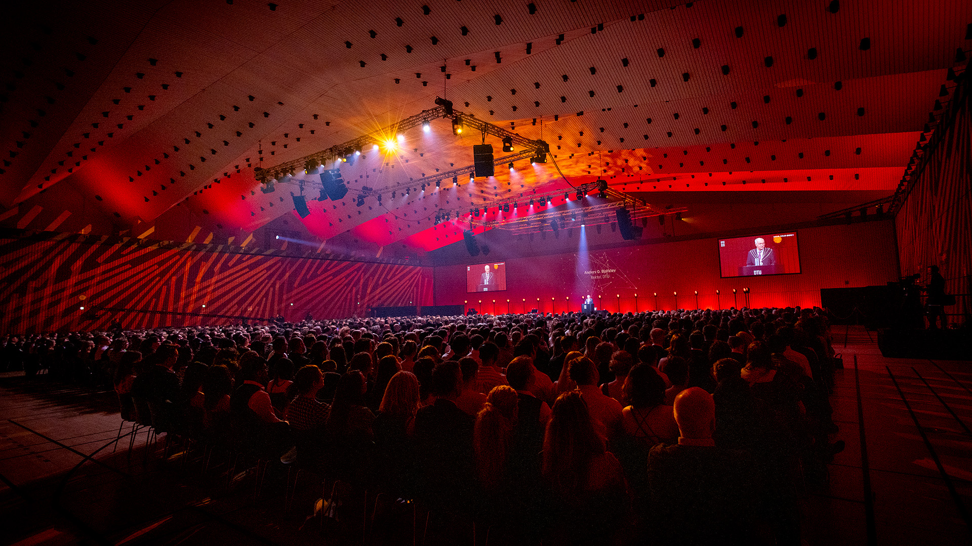 Coloured floodlights set a festive mood in the darkened sports hall at DTU Lyngby Campus. Photo: Steen Brogaard.